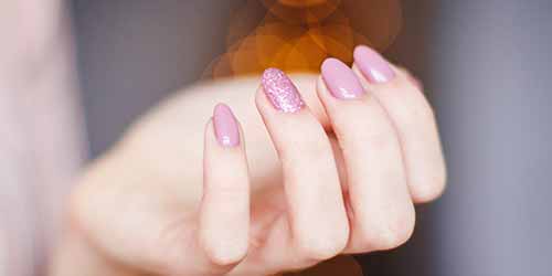 woman's hand with pink manicure