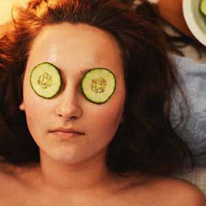 woman with cucumbers on her eyes at the spa